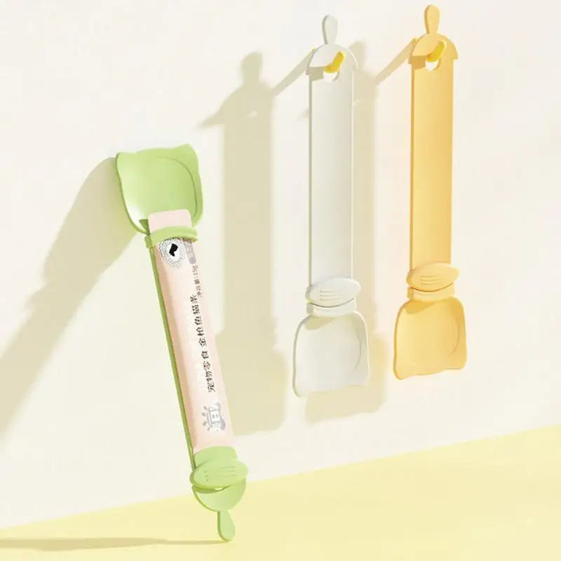 Reusable cat strip feeder squeeze spoon in orange, green, and white, designed for serving wet food and treats. Easy to clean and perfect for bonding with your pet during snack time.