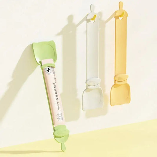 Reusable cat strip feeder squeeze spoon in orange, green, and white, designed for serving wet food and treats. Easy to clean and perfect for bonding with your pet during snack time.