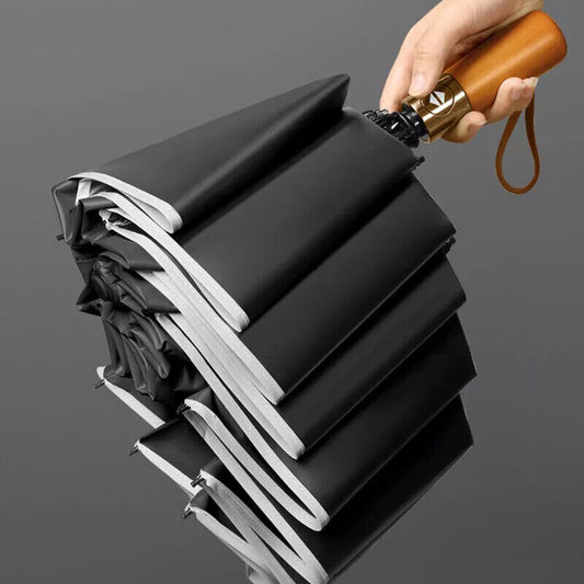 Folded black umbrella with wooden handle on a dark gray background